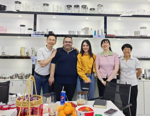 Zhongshan Yuekon Electrical Appliances Co.، ممثلون محدودون يقفون مع العملاء الدوليين، مما يدل على علاقات تجارية قوية.